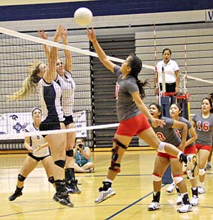 Monument Valley’s Taylor Worker tips the ball over two Piedra Vista defenders during the championship match of Piedra Vista’s Panther Classic held Sept. 12-13. Worker played a key role in the Lady Mustang’s success. (Times photo - Sunnie R. Clahchischiligi)