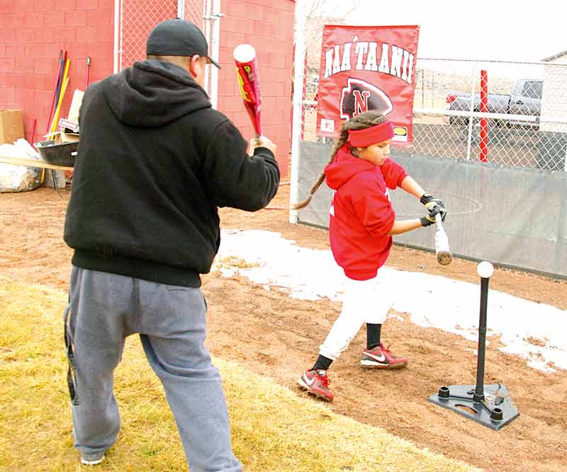 A NaatՇanii Baseball Academy coach teaches Sieane M. Lons, 10, on how to hit a baseball, one of the most difficult skill in all sports, on Jan. 10 at the Sand Devil baseball field in Page, Ariz. Thirty-one participants took part in the baseball camp, which was coordinated by professional baseball players, brothers Craig and Vincent Littleman from LeChee, Ariz. (Times photo - Krista Allen) 