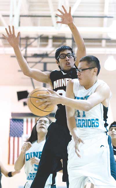 Diné Warrior Demar Whitehorse (11) passes the ball around Leo Peacock of Red Valley-Cove on Saturday. (Times photo – Donovan Quintero)
