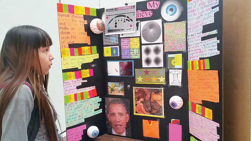 A student at Ganado Elementary School looks at the “I Can’t Believe My Eyes” science project that talks about optical illusion during the Ganado Pee Wee Science Fair on Feb. 3. (Times photo — Shondiin Silversmith)