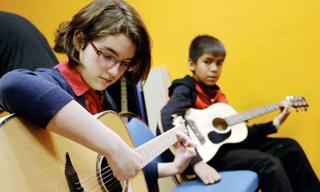 Youth learn to play, tune guitars at music workshop