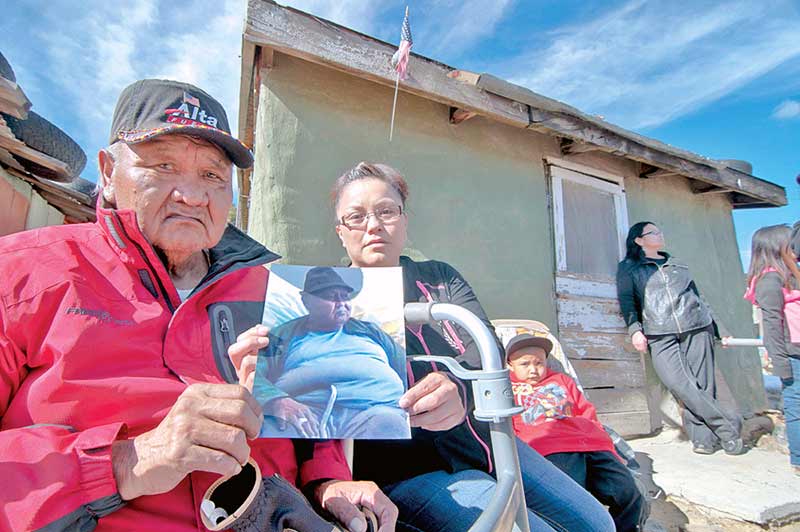 Younger brother of slain Wilson Joe Chiquito, Willie Chiquito, left, and granddaughter Marshie Pablo, hold a photograph of him on Feb. 12 outside of what used to be his home in Day Mesa, which is 8 miles southwest of Counselor, N.M. According to Pablo and the FBI, her grandfather was killed by an unknown person or persons last year. The FBI is offering a $1,000 reward for information related to the murder. (Times photo - Donovan Quintero)