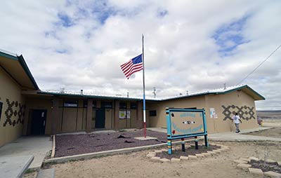 The flag sits at half-mast outside of the Sanostee Chapter on Friday afternoon in Sanostee, N.M. in honor of Navajo police officer Alex Yazzie who was shot and killed during a shootout with Little Water, N.M. resident Justin Fowler on Thursday night at the base of the Chuska Mountain in Cove/Red Valley, Ariz. on Navajo Route 13. Two other officers, Herbert Frazier and James Hale each took a bullet to the leg. Hale was transported to the University of New Mexico hospital and Frazier was taken to the Shiprock Medical Center. (Times photo - Donovan Quintero)
