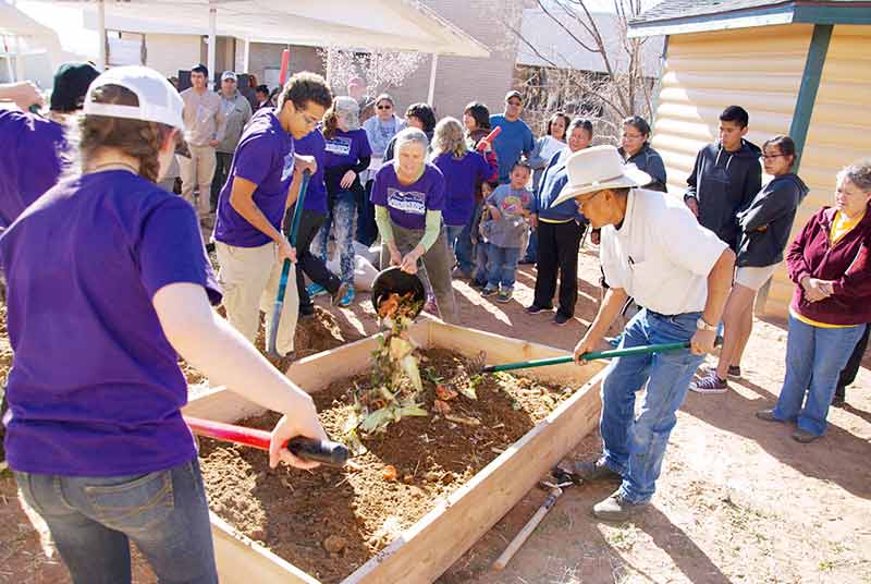 Tuba City native Guy Sloan (right) helps Kim Howell-Costion (center) and her young helpers establish a raised-dug lasagna bed in the healing garden on Saturday morning during Tuba City Regional Health Care Corp.’s annual garden expo. (Times photo – Krista Allen)