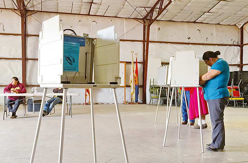 Three Tonalea-Red Lake voters stand at the voting booth on Tuesday afternoon to cast their ballot for the Navajo Nation special election. According to unofficial results, Begaye-Nez received 257 votes here while Shirley-Benally received 195 votes. (Times photo – Krista Allen)