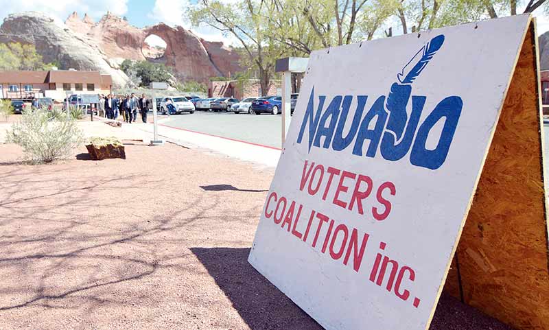 A Navajo Voter's Coalition Inc. sign sits outside the Navajo Nation Council Chamber as Navajo Nation President Ben Shelly and staff members make their way inside on Monday, April 20, 2015, in Window Rock. (Times photo - Donovan Quintero)