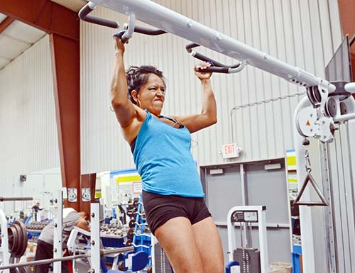 Valerie Long, a bodybuilder and mother of six, works on her pull up at the Gallup Fitness Center. (Times photo – Paul Natonabah)