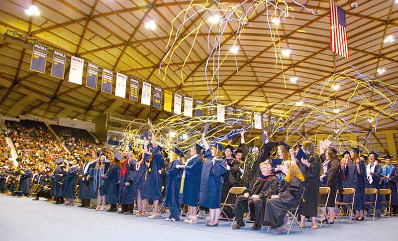 After the conferring of degrees on Friday afternoon, graduates celebrate and raise their arms in victory after Northern Arizona University’s commencement ceremony at the J. Lawrence Walkup Skydome in Flagstaff. (Times photo – Krista Allen)