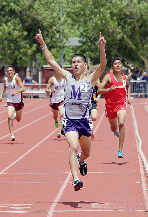 Miyamura High School junior Niles Thomas raised his hands in celebration as he crosses the finish line in first place at the 2015 New Mexico Activities Association State Track and Field 5A boy’s 1600-meter race. Thomas hit a personal best of 4:22 for his first state track and field title. (Times photo – Sunnie R. Clahchischiligi)