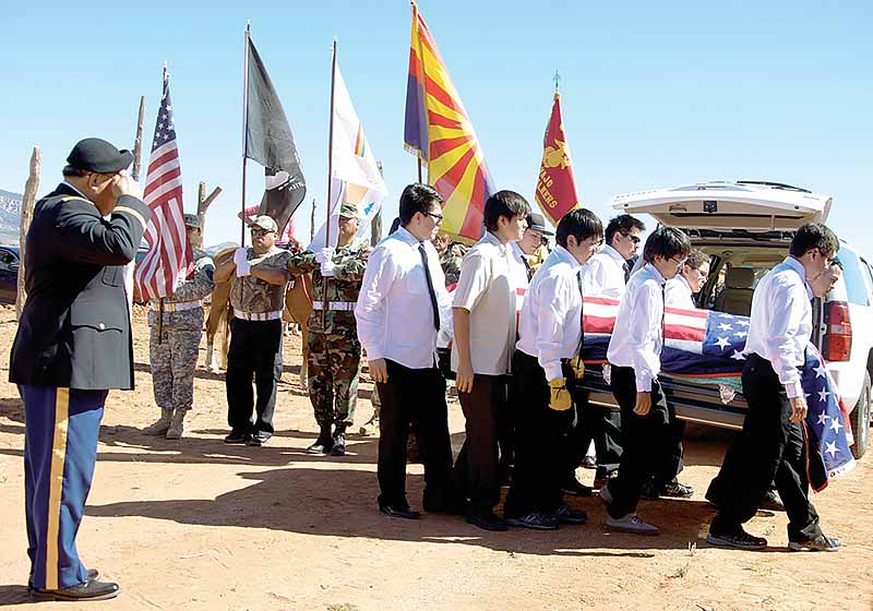 A soldier salutes as the honorary pallbearers carry the casket of the late Navajo Code Talker Bahe Ketchum on Saturday morning at the Ééhániih Day event grounds, where the service took place, in Naatsis'áán, Ariz.  (Times photo – Krista Allen)