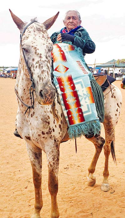 Julia Fatt from Paiute Mesa, Ariz. was honored with a Pendleton blanket at Ééhániih Day, held on Saturday at Naatsis’áán, Ariz. As she’s done numerous times in the past, Fatt, also known as “Grandma on horseback,” rode her horse in the mini parade, which kicked off the annual celebration. (Times photo – Candace Begody-Begay)
