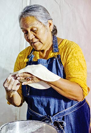 Special to the Times | Alysa Landry Marilyn Barber, of Upper Fruitland, stretches her dough on practiced hands before lying it in sizzling grease. 