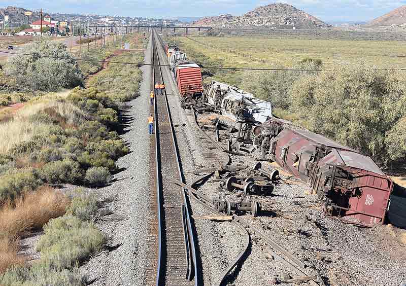 Navajo Times | Donovan Quintero BNSF Railway officials walk along the railway as they begin their investigation how a train, heading westbound, derailed early Friday morning east of Gallup.
