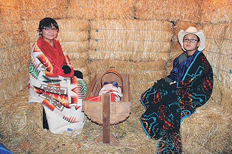 Submitted Children dressed as Mary, Joseph and the baby Jesus sit in a makeshift stable at Navajo Ministries during the annual Live Nativity. 