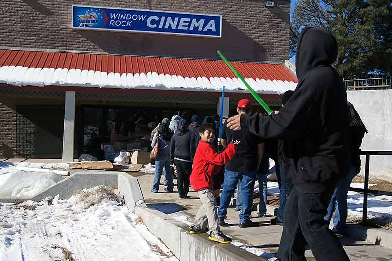 Navajo Times | Christopher S. Pineo Deacon Lee Curley, 9, attempts to "use the force" on his dad Brandon Begay, 26, of Window Rock as they wait in line for tickets to see “Star Wars: Episode VII – The Force Awakens” later that day. 