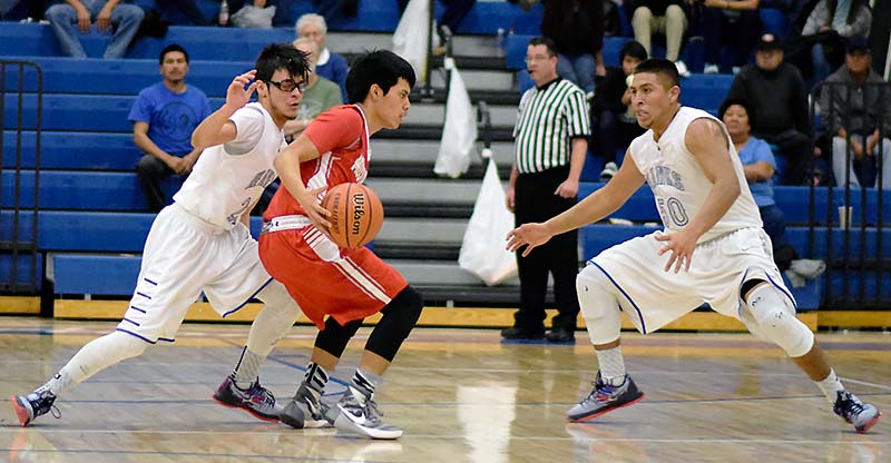 Navajo Times | Donovan Quintero Monument Valley Mustang Irwin Holiday, red jersey, keeps the ball away from Laguna Acoma Hawks Matt Sanchez, left, and Jacob Aragon (50) Thursday night in Casa Blanca, N.M. The Mustangs defeated Laguna Acoma, 75-70, and will face the Zuni Thunderbirds at 4:30 p.m. at the University of New Mexico Johnson Center in Albuquerque, N.M. 