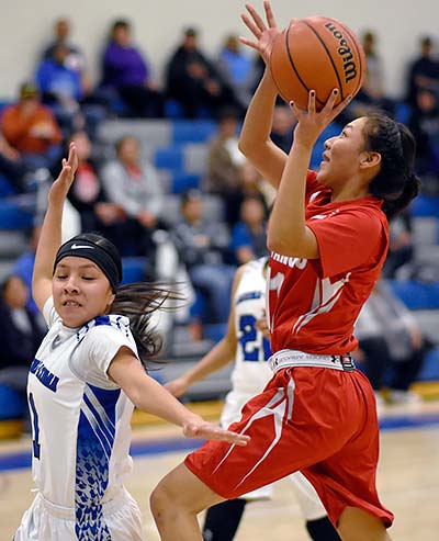 Navajo Times | Donovan Quintero Monument Valley Lady Mustang Shayla Yazzie, red jersey, sets up for a shot as Laguna Acoma Lady Hawk Shaylyn Smith attempts to block her Thursday night in Casa Blanca, N.M. during the Striking Eagle Basketball Invitational. Monument Valley defeated the Lady Hawks, 66-58. They will play the Grants Lady Pirates at 3 p.m. at the University of New Mexico Johnson Center in Albquerque, N.M. 