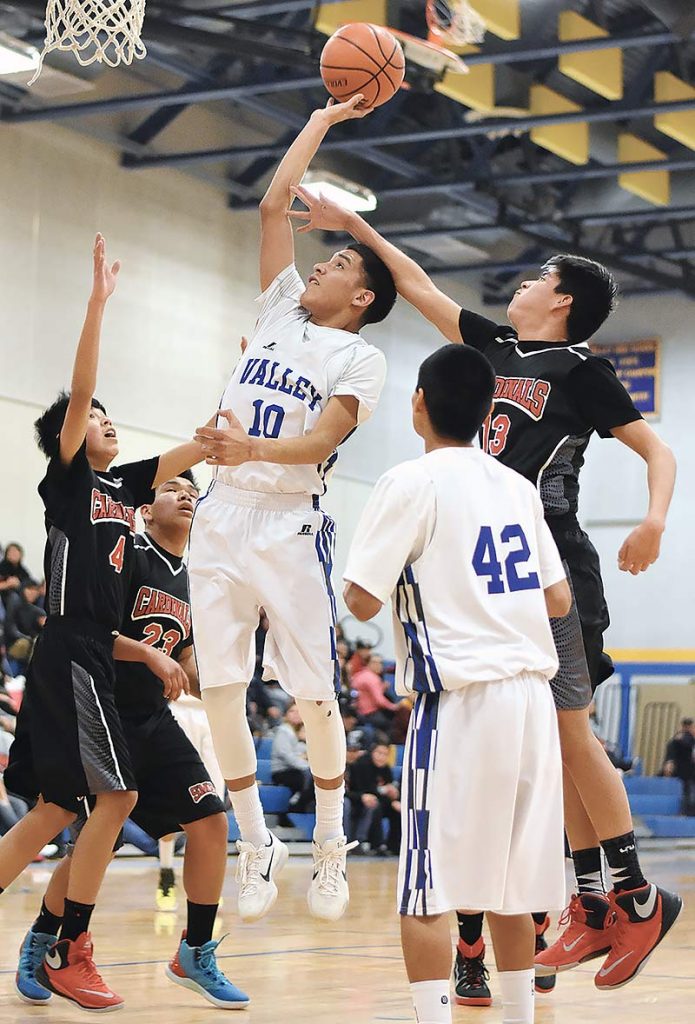 Navajo Times | Donovan Quintero Valley Sanders Pirate Apollo Smith (10) aims the ball for the basket as St. Michael Cardinal Caleb Duncan (13) reaches up for an attempted block Saturday in Sanders, Ariz. 