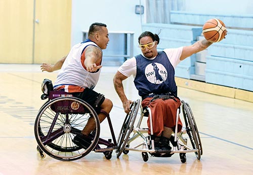 Navajo Times | Donovan Quintero Arizona Wildcat Mario Moran, right, holds the ball out and away from Marcus Chischilly, Saturday, June 18, 2016, during a scrimmage of wheelchair basketball at the Window Rock High School in Fort Defiance.