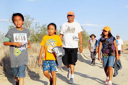 Sunnie R. Clahchischiligi | Navajo Times A grandfather and his grandchildren continue on the final leg of the 2016 Just Move It trail in Shiprock. The finale had one of the largest crowds at JMI event this year.