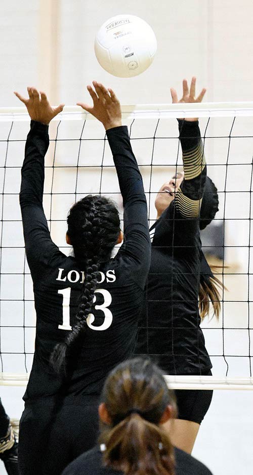 Navajo Times | Donovan Quintero Chinle Lady Wildcat Elysa Harwood, right, sets up to spike the ball against defending Many Farms Lady Lobo Shalaya Slim (13) Tuesday evening in Many Farms, Arizona.