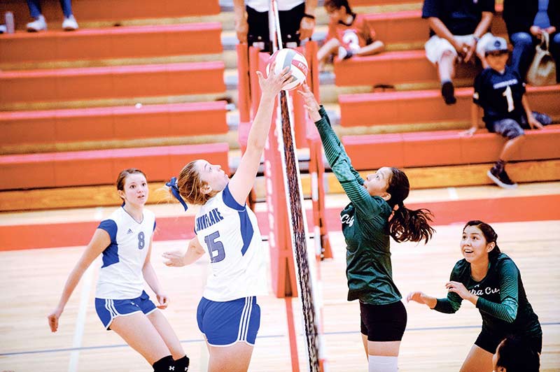 Navajo Times | Adron Gardner Snowflake Lobo Erin Willis (15), left-center, and Tuba City Warrior Jayda Chee (9) meet above the net as Lobo Elle Flake (8), left, and Warrior Kourtney Posey (3) look on during the Kayenta Township MV Mustang Volleyball Tournament Sept. 24.