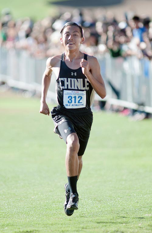 Navajo Times | Donovan Quintero Chinle Wildcat Santiago Hardy smiles as he prepares to cross the finish line in first place Saturday during the Arizona Division III Cross Country Championships in Phoenix.