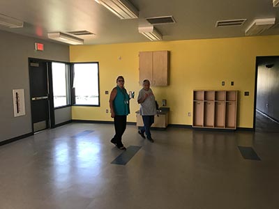 Two staff members walk across empty room