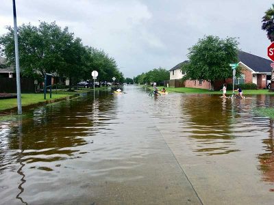 Kids ride bikes, boat, and run in floodwaters