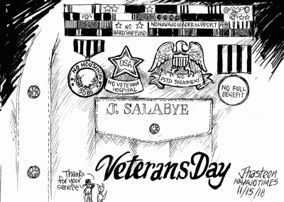 Close-up of veteran's right shirt pocket, with name of J. Salabye and words Vetearns Day. Medcails include: No Housings, jobs. No VVeteran Hospital. No PTSD Treatment. No full benefit. Sidekicks say, Thank you for your service.