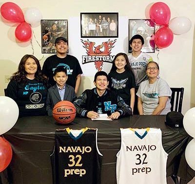 Navajo Prep grad signs with ACU