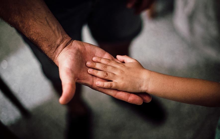 Child's hand in hand of father.