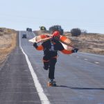 A Navajo Nation flag on his shoulders, he skates the long road toward Shiprock