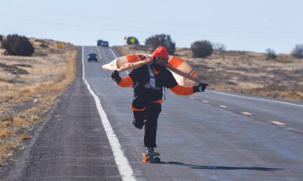 A Navajo Nation flag on his shoulders, he skates the long road toward Shiprock